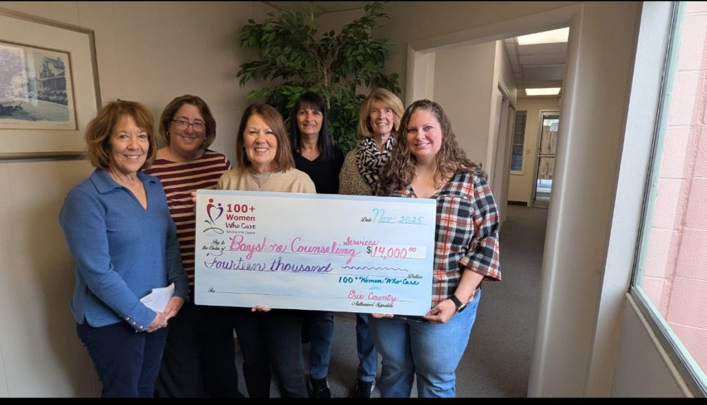 Representatives of 100 Women present checks to Bayshore Counseling Services Board members
