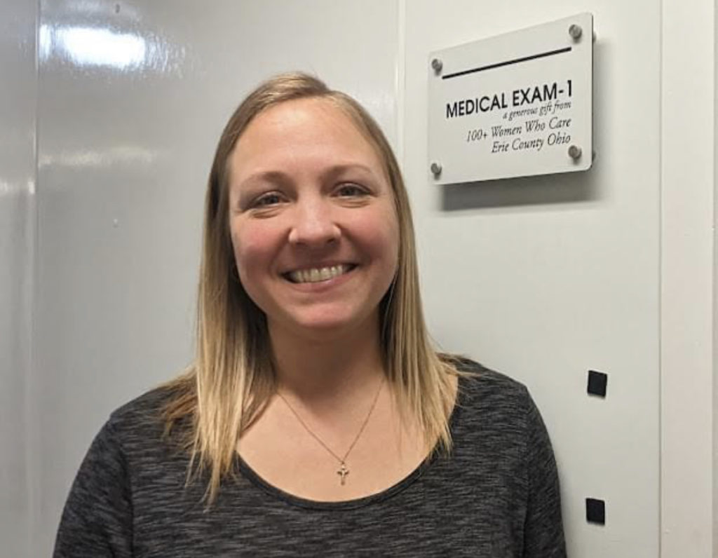 Melissa Gundlach at Humane Society with plaque honoring 100+ Women Who Care